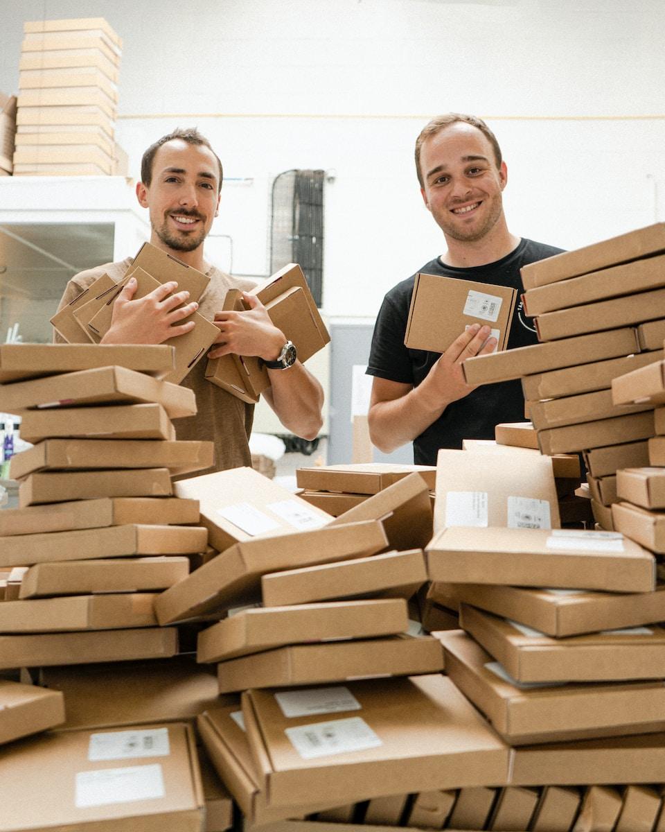 a couple of men standing next to a pile of boxes